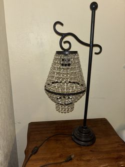black metal table lamp with a hanging crystal chandelier shade