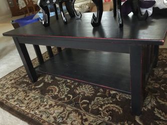 Black with some red at the edge tv table with bottom shelf