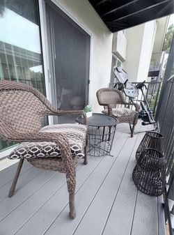 2 balcony chairs with a table and decoration