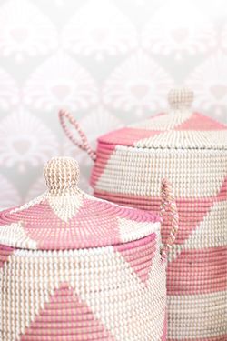 a handwoven Senegalese laundry basket with a pink and white geometric design.