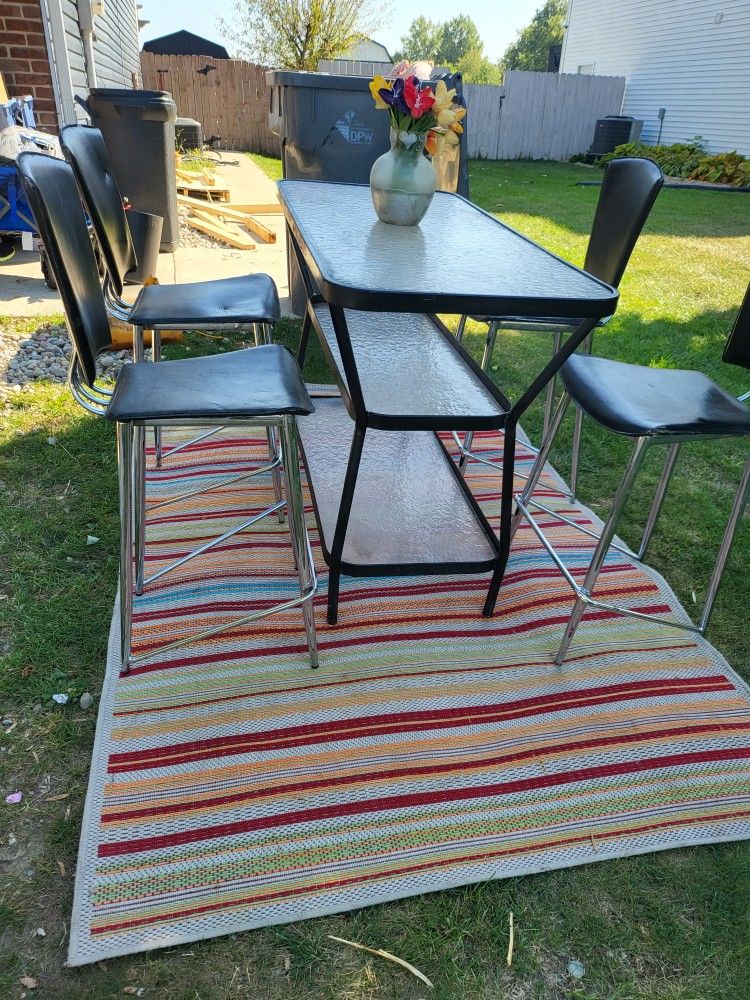 Cute Three Tier Tall Table With Four Stools And A Colorful Rug