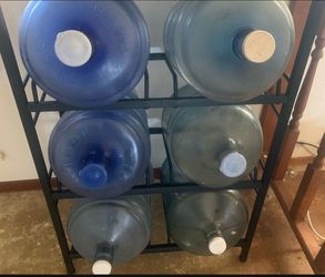 5 gallon jug holder with 6 jugs one has a spout