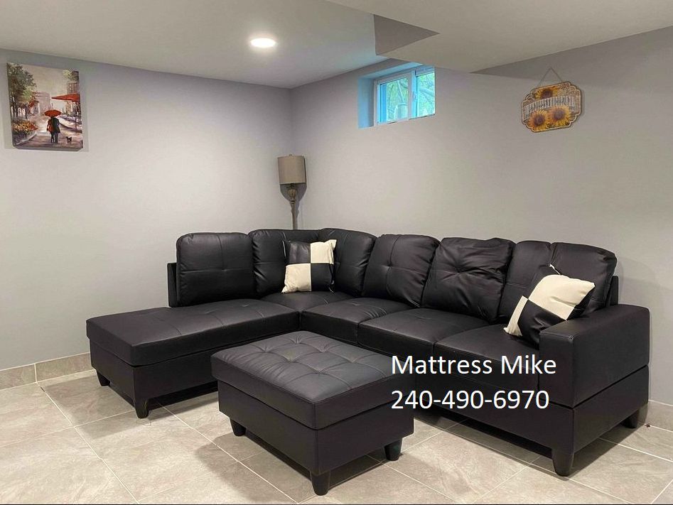 New in box black faux leather sectional with ottoman and pillows