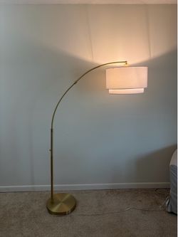 Knurled metal arc floor lamp with tiered shade brass