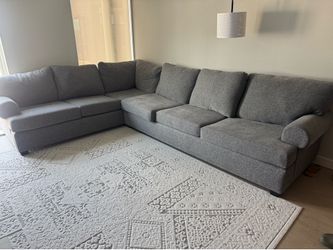 Gray Sectional couch with queen pull out bed.