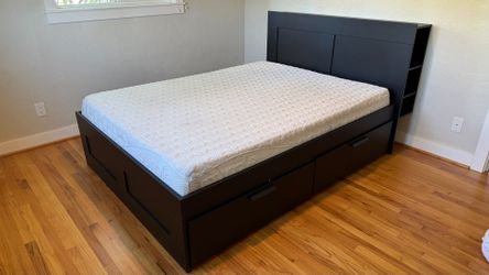 IKEA black queen sized bed with storage and headboard