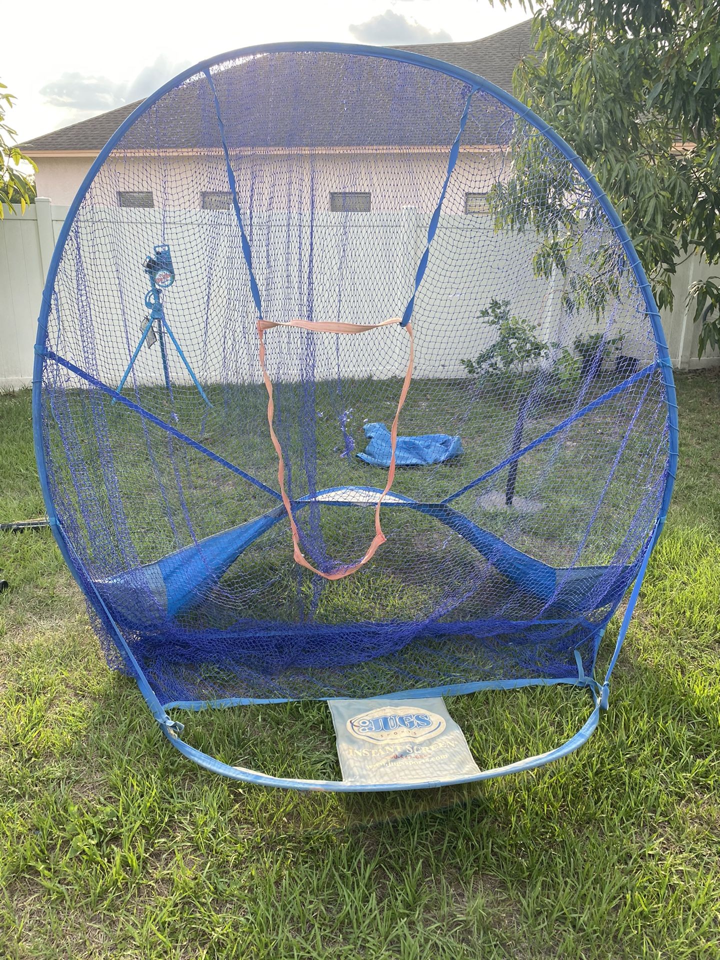 Baseball net with batting tee and bucket of balls