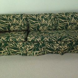 Green and white sofa. Has 6 throw pillow of same material and different sizes. Pillows not shown.