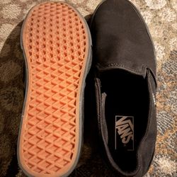 all-black Vans Classic Slip-On shoes.