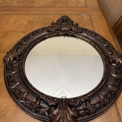 Round accent mirror with bronze carving