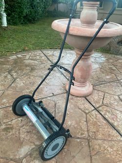 Manual push lawnmower in great working condition .