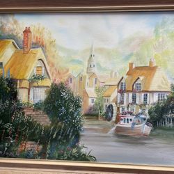 framed oil painting featuring a picturesque village scene