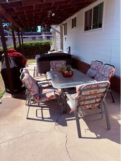 Patio table and chairs with cushions included for six people.