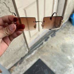 sunglasses with a gold metal frame and or brown tinted lenses. 