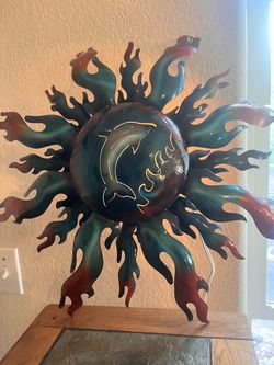 handcrafted metal sun wall art sculpture featuring a cut-out dolphin and wave design