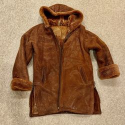 Women's sheepskin coat with natural lamb fur and leather trim.