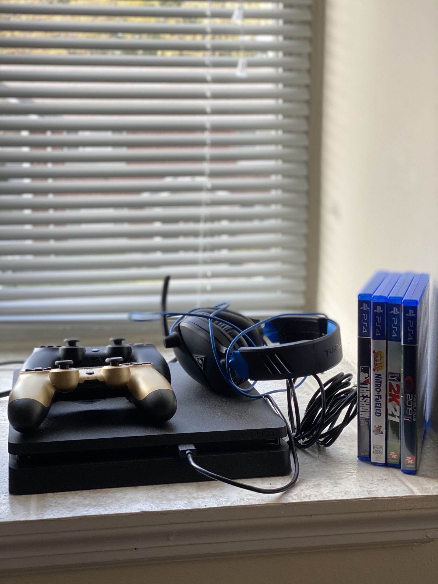 PS4 with headset, games, and controllers.