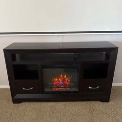 Dark wood TV stand with a built-in fireplace