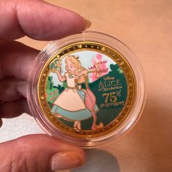 D23 the ultimate Disney fan event 2026 Alice in Wonderland 75th Gold Medallion Coin in plastic case.