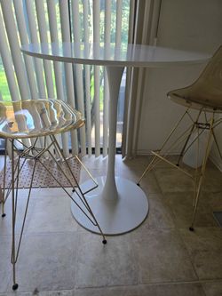 White Round Tulip Pedestal Table with 2 bar height chairs. Modern and sleek style