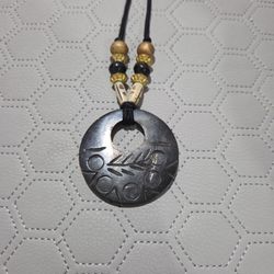 BLACK CORD NECKLACE WITH ROUND CARVED PENDANT 