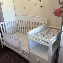 White baby crib with attached storage and mattress included