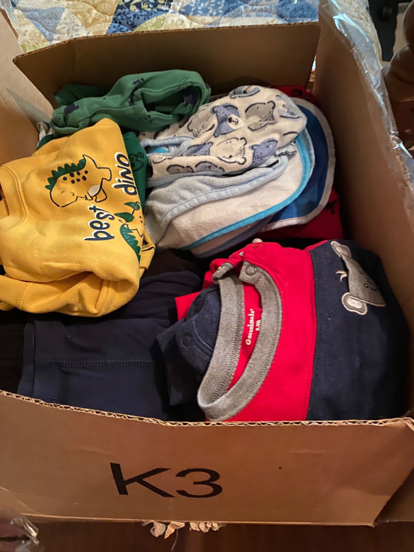 Box full of baby boy clothes bibs baby rags and blankets