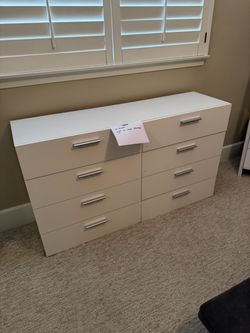 Modern white dresser with eight drawers and horizontal silver-toned drawer pulls