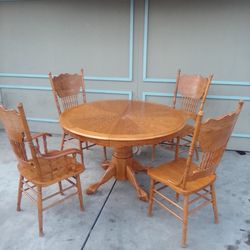 Classic solid oak round pedestal table with matching pressed back spindle chairs