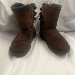  UGG brand baby boots, likely one of their classic infant bootie styles in a brown or "chestnut" color  Woman Size 7
