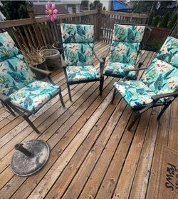 Four outdoor metal chairs with cushions