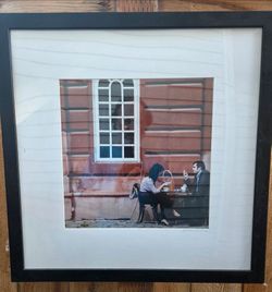 Framed art work in black wooden frame