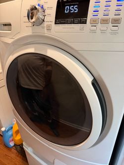 White Front-Load Washing Machine and Dryer with Pedistals