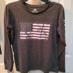 Women's Mossy Oak long-sleeve t-shirt featuring a gray body and a pink camouflage American flag graphic on the front. Sz M