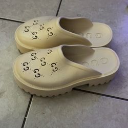 Gucci Elea perforated rubber platform mules in mystic white or cream. 