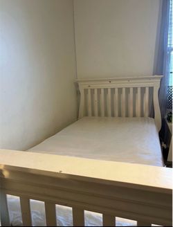 Wooden drawer with a mirror and bed with mattress