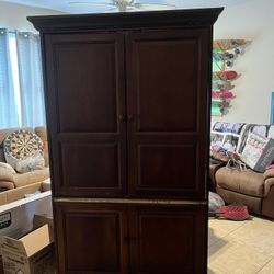 Large wood armoire able to fit tv in. Two doors underneath for storage.