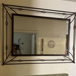 This mirror is made of bronze finish metal and glass. Measures 25x33.