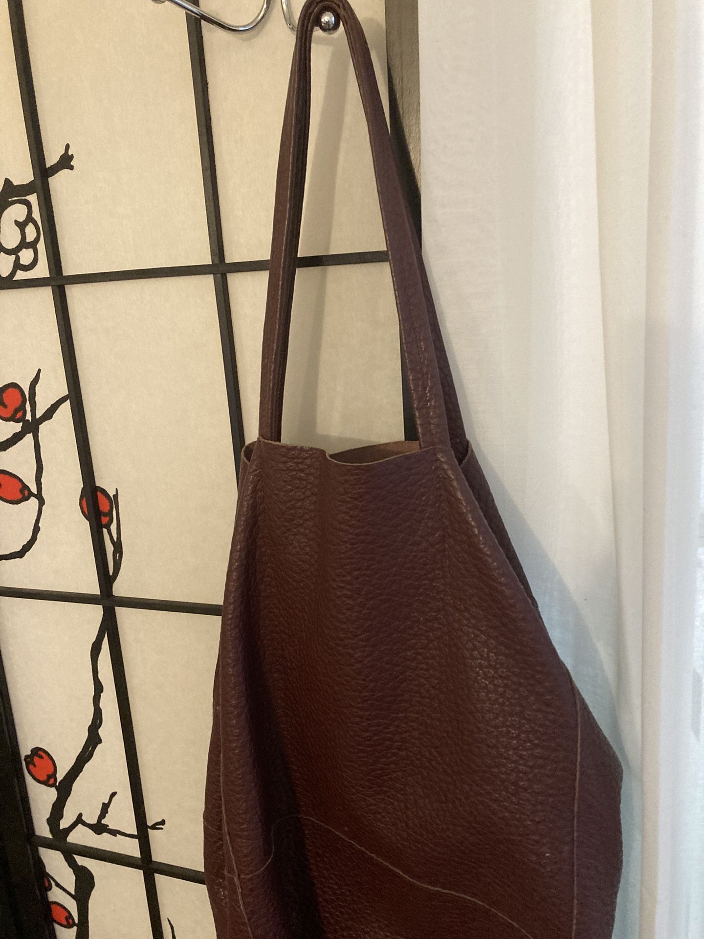 Here's a large Italian leather tote bag in a beautiful burgundy color. It's an oversized bag perfect for everyday use or travel. The leather has a nic