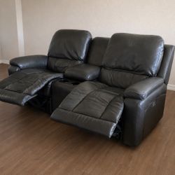 This is a La-Z-Boy electric power reclining loveseat (two-seater sofa) with center console. Upholstered in genuine dark brown leather (near-black/gray
