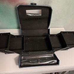 A blue denim-style makeup train case with six cantilever trays and a mirror