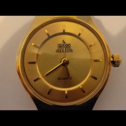 Quartz Watch Featuring A Gold Tone Face With Black Leather Band