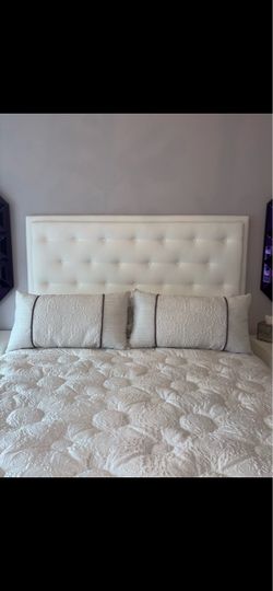 Beautiful white tufted headboard with large dresser and side dressers and bench