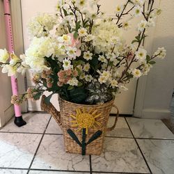 Beautiful artificial flowers in handwoven watering basket
