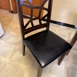 A stylish wooden chair with a decorative lattice back and a black padded seat, suitable for dining or casual seating. 6 chairs all togther $235 