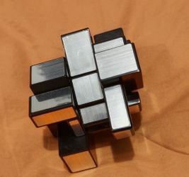 Scrambled Silver Mirror Cube (also known as a Mirror Blocks cube or Bump Cube), a 3x3x3 twisty puzzle, variant where solving relies on matching shapes