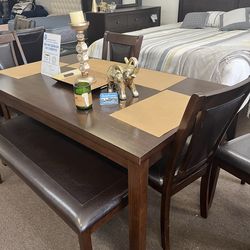 Brown table 4 chairs and a bench