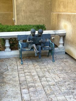 bronze statue of children reading a book