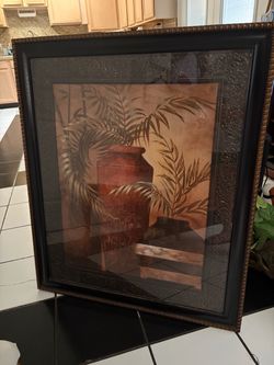 Have big pictures frame with 2 wall sconces with green leafs