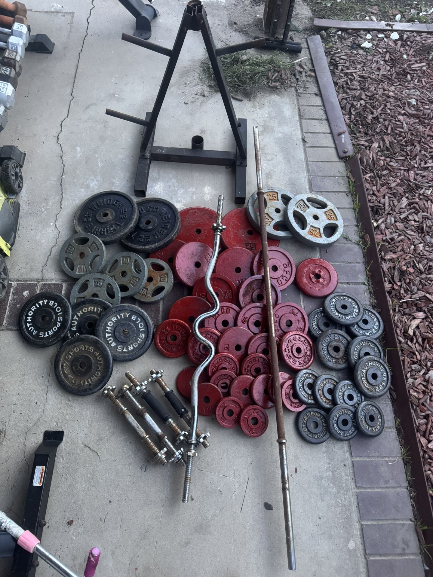 Standard weights with 425lbs total plus 6ft bar and curl bar and two pairs of adjustable dumbbells and weights tree